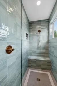 Each main-floor primary suite features a walk-in, spa-style tiled shower with glass enclosure and premium fixtures—an elevated, inn-worthy start and end to your day at the lake.
