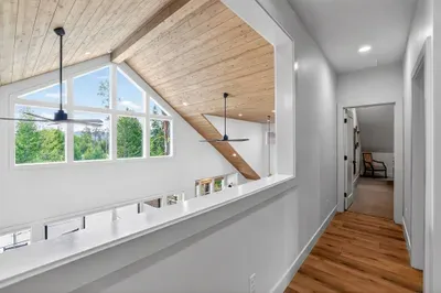 The loft picture window visually connects the upper level with the great room, maintaining a shared-house feeling and offering incredible mountain and treetop views