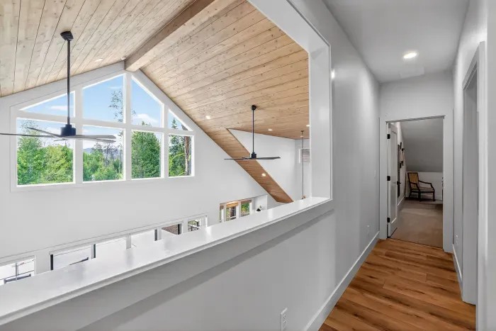 The loft picture window visually connects the upper level with the great room, maintaining a shared-house feeling and offering incredible mountain and treetop views