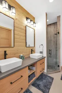 Double vanities in the primary ensuite, which also has a spacious walk-in shower with river rock tile