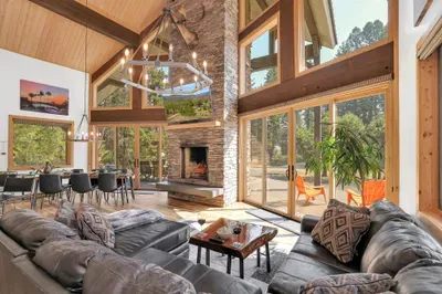 The floor to ceiling windows and double glass sliders to the wraparound deck let in an incredible amount of natural light, and seamlessly blend indoor/outdoor living