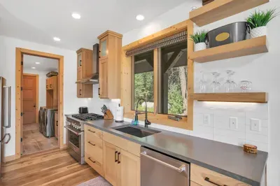 Top of the line KitchenAid appliances, including a 6-burner gas range, dishwasher, french door refrigerator, and full-size Whirpool front load washer/dryer in the mudroom. Half bath is off the laundry room