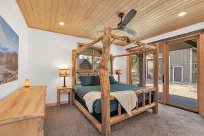 The primary bedroom is so relaxing, complete with a king-sized canopy bed, slider to the wraparound deck, and an ensuite bath