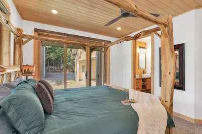 The primary bedroom is so relaxing, complete with a king-sized canopy bed, slider to the wraparound deck, and an ensuite bath