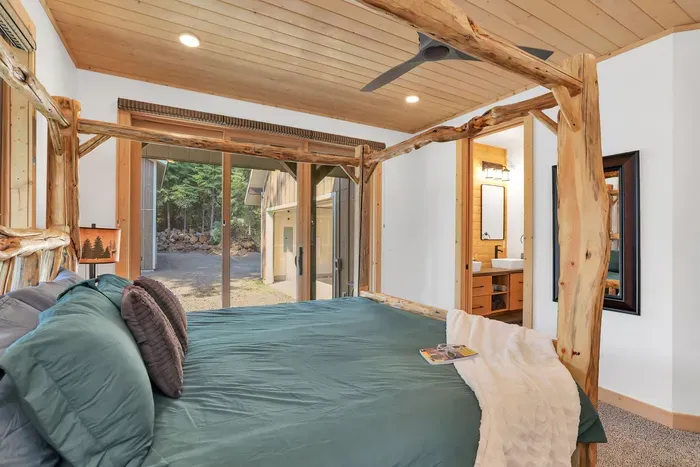 The primary bedroom is so relaxing, complete with a king-sized canopy bed, slider to the wraparound deck, and an ensuite bath