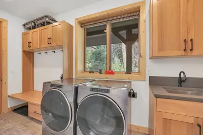 Right off the attached garage, the mudroom is such a luxurious addition! With built-in shelving for storing your gear, full-size front load Whirlpool washer/dryer, and a utility sink, your outdoor equipment can stay separate from the main house