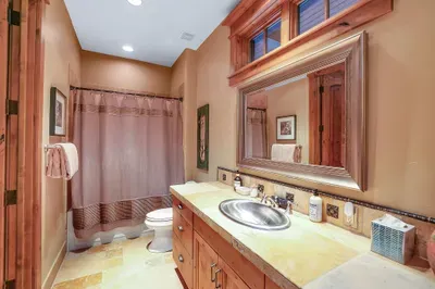 The ensuite’s shower/tub combo keeps routines easy; crack the patio door for cool mountain air and slip straight to the built‑in stone spa