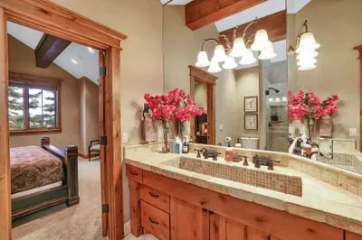 Morning light, pine views, and a handsome tiled trough sink built for two. The large walk-in shower keeps things simple and unrushed