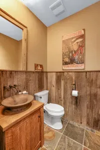 A nod to the West—hammered copper sink, warm timber, and iron accents give the downstairs powder room a handsome, frontier finish