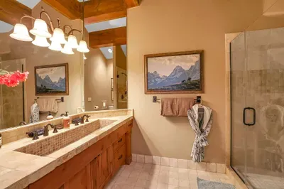 Upstairs king suite with a calm, grounded feel—crisp linens, a beautiful walk-in shower, and a gorgeously tiled trough sink as the room’s statement piece