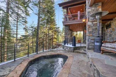 Hot tub on the lower patio, deck stretching above—two levels of outdoor living that keep you outside from first light to last call