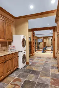 The daylight basement is your gear hub—built‑in ski racks, lockers, a second set of washers/dryers, and a door straight to the trail make mornings seamless. Warm up before first chair in the fitness room—commercial bike and elliptical included