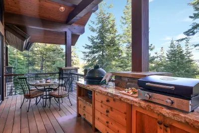 The kind of deck that earns its keep—grills fired, fire lit, peaks framed, and no one ready to go inside yet