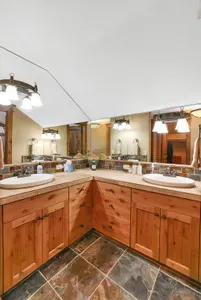 Mornings move smoothly here—two sinks at the ready, soft light at the mirror, and a hot soak or quick rinse within reach