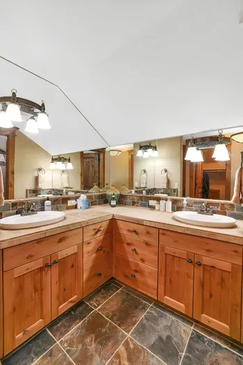 Mornings move smoothly here—two sinks at the ready, soft light at the mirror, and a hot soak or quick rinse within reach