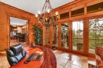 A proper office at tree level—floor-to-ceiling views, a beautiful wood desk with printer, and a crackling gas fireplace. Step to the patio when you need a breath of pine