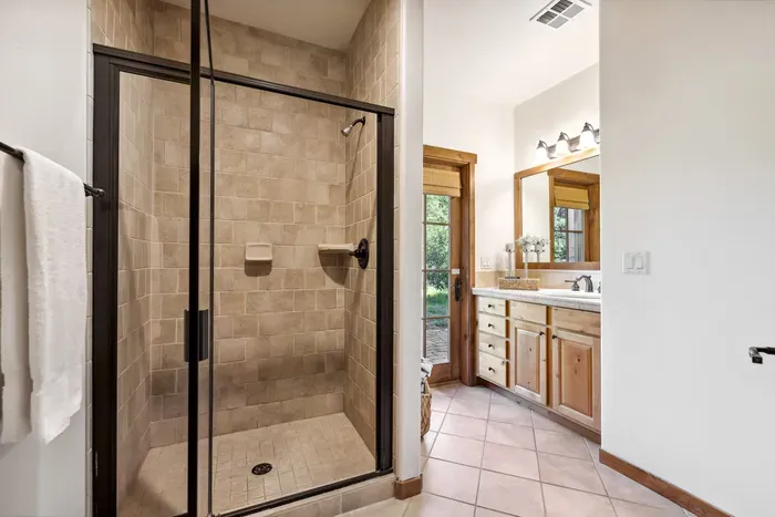 The guest bedroom has its own private bathroom with a walk-in shower