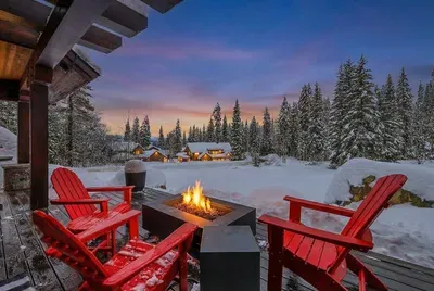 Wraparound deck designed for unhurried evenings: outdoor fireplace, grill, multiple seating areas, and big‑sky sunsets.