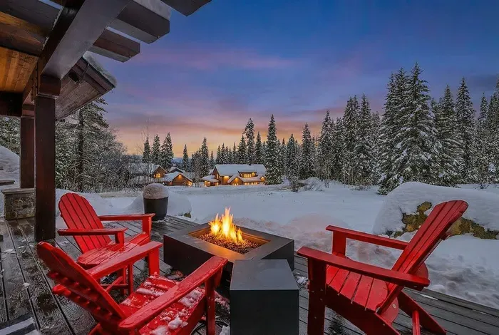 Wraparound deck designed for unhurried evenings: outdoor fireplace, grill, multiple seating areas, and big‑sky sunsets.