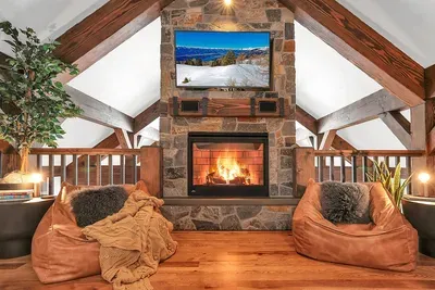 Loft lounge with its own fireplace and queen sleeper—perfect for game nights, late‑night conversations, or a quiet read.