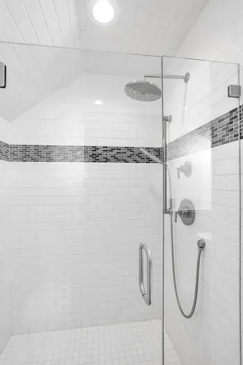 Step into the apartment's full bath, featuring a beautifully tiled walk-in shower that offers a touch of luxury and a refreshing retreat.