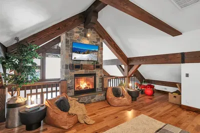 Fire, soft textures, and a calm palette make the loft an easy place to land between first chair and last call.