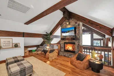 The loft is your perch above it all—open, relaxed, and wrapped in warm light from the windows and fireplace.