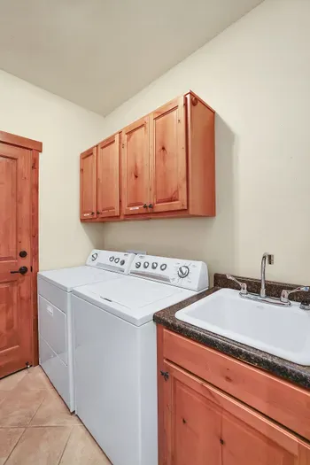 Discover the convenience of a spacious laundry room, complete with a full-sized washer, dryer, and utility sink, ensuring all your laundry needs are met effortlessly during your stay