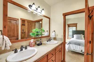 Shared Convenience: The Jack & Jill bathroom connects the guest bedrooms, offering a practical and stylish solution with double vanities that make morning routines a breeze