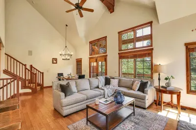 Large windows flood the open living space with natural light and offer stunning mountain views, creating a serene and inviting atmosphere