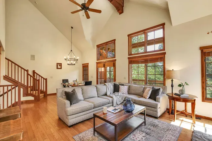 Large windows flood the open living space with natural light and offer stunning mountain views, creating a serene and inviting atmosphere