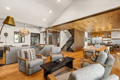 This open concept main floor living space is a dream, offering access to the garage, mudroom/laundry room, dining area, kitchen, balcony, a powder room, and the primary bedroom. Did we mention the views???