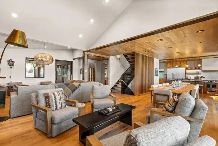 This open concept main floor living space is a dream, offering access to the garage, mudroom/laundry room, dining area, kitchen, balcony, a powder room, and the primary bedroom. Did we mention the views???