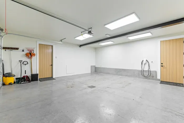 Attached heated garage keeps cars, skis, and bikes out of the elements. Tesla charger included