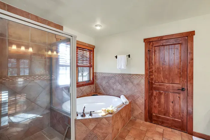 Soothe ski legs and trail miles in the deep soaker tub, then rinse off under the walk‑in shower—your own mini spa just off the bedroom