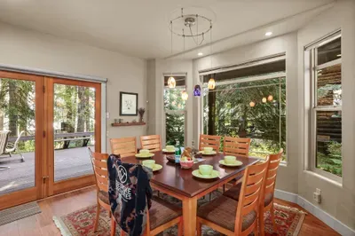 We love the panoramic windows, seamlessly blending nature into the home. With plenty of seating and a fully-stocked kitchen, home-cooked meals are a great option if you love to cook!