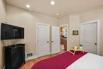 The main floor bedroom has a king-sized bed, walk-in closet (outdoor gear stored inside), ensuite bathroom access, and a 43" smart TV (BYO logins)
