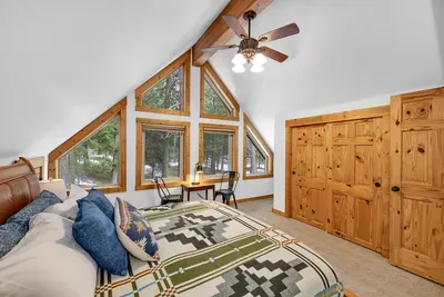 Primary king bedroom upstairs: spacious, calm, and perfectly cabin-cozy.