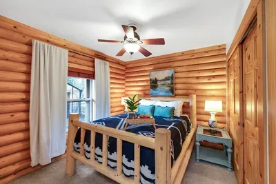 Embrace the enchanting log cabin charm of Otter's Den, where the warmth of wood, cozy Pendleton blankets, and thoughtful decor create a cozy, inviting atmosphere that truly feels like a home away from home