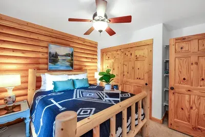 This cozy queen bedroom on the main floor offers a peaceful haven with its charming decor and easy access to the heart of the cabin