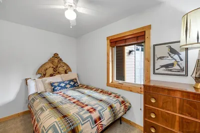 This downstairs queen bedroom offers both comfort and convenience, featuring built-in shelving for easy organization and a cozy retreat for a restful night's sleep