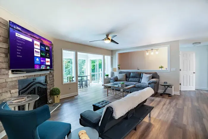 Bright and airy open concept living room equipped with a 75" Smart TV.