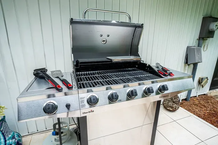 New Charbroil 5-burner gas grill and grilling utensils can be used to enjoy a feast while relaxing in the serenity of the fully fenced in backyard.