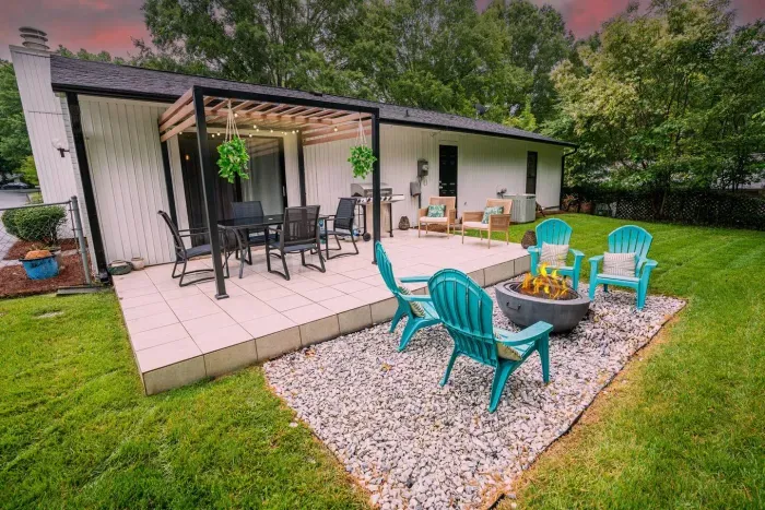 Peaceful backyard patio with plenty of options for seating, a 5-burner gas grill, and firepit to sit back and unwind.
