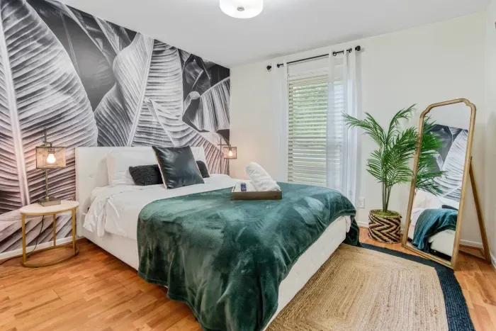 Relax in the uniquely curated design of the queen bedroom with queen bed, plenty of pillows, two nightstands, 40" Roku TV, and workstation.