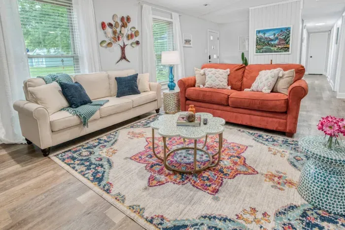 Living room seating, pillows for comfort, and a thick throw blanket. The red sofa can be pulled out into a full bed. Bedding for the pull out is kept in the laundry room.