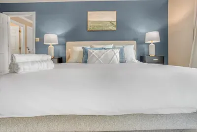 Cozy king sized bed w/ plenty of pillows in the primary bedroom.