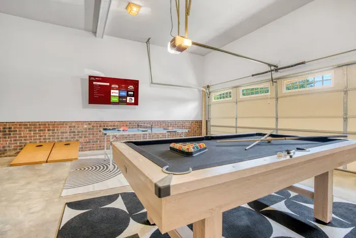 Also equipped with a wall-mounted TV, cornhole boards, and a ping pong setup — perfect for hours of indoor fun and friendly competition.