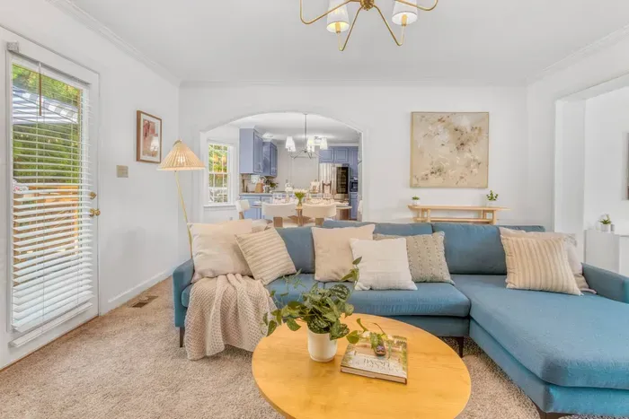 Living area and the open archway that leads into a chic dining area and kitchen, creating a seamless flow.
