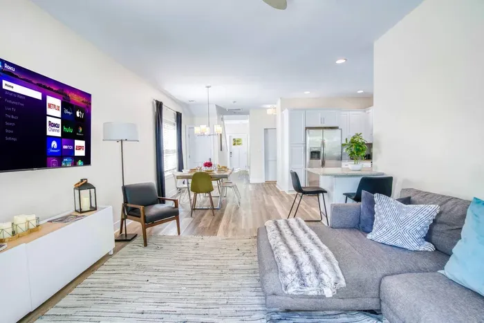 Open-concept living area with modern décor, smart TV, and seamless flow to dining and kitchen spaces.